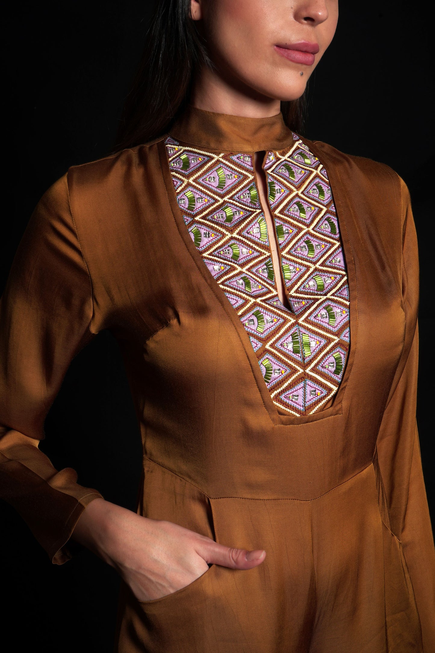 Golden brown jumpsuit featuring geometric hand-embroidery