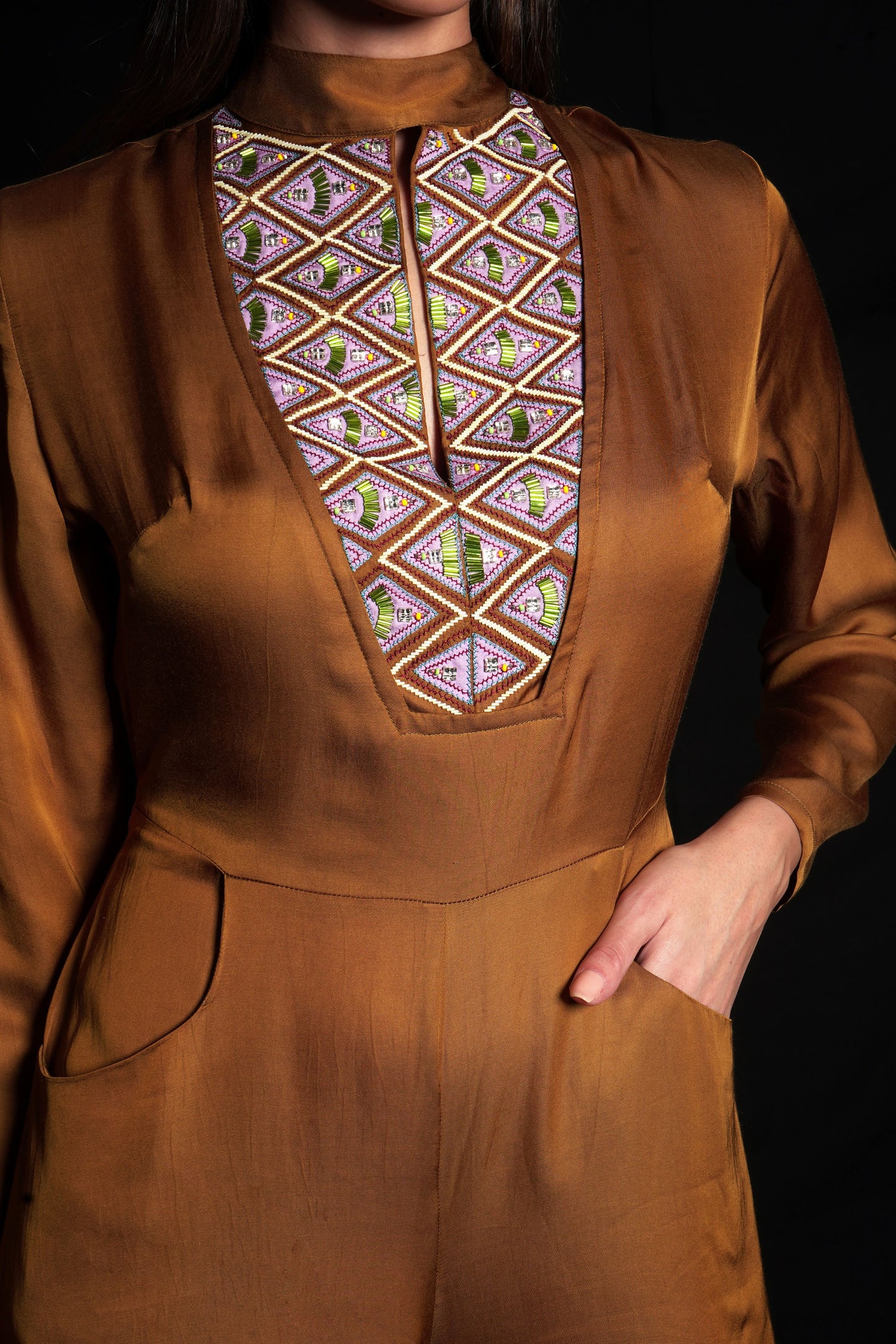 Golden brown jumpsuit featuring geometric hand-embroidery