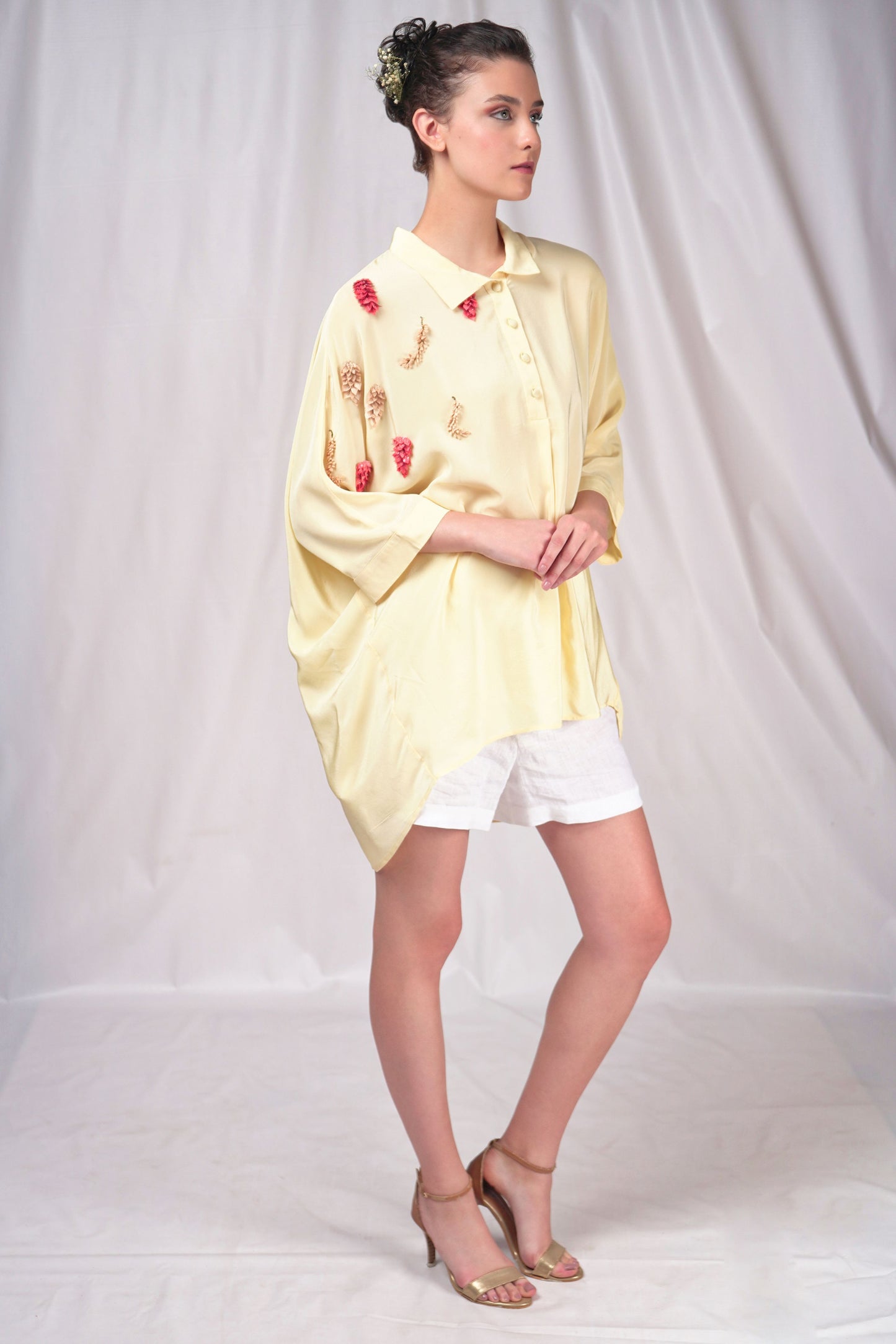 Cream-hued loose fit button-down top with minimal embroidery
