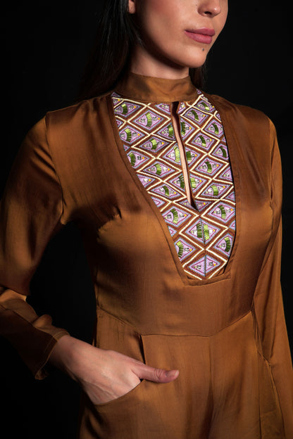 Golden brown jumpsuit featuring geometric hand-embroidery