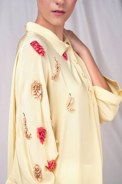 Cream-hued loose fit button-down top with minimal embroidery